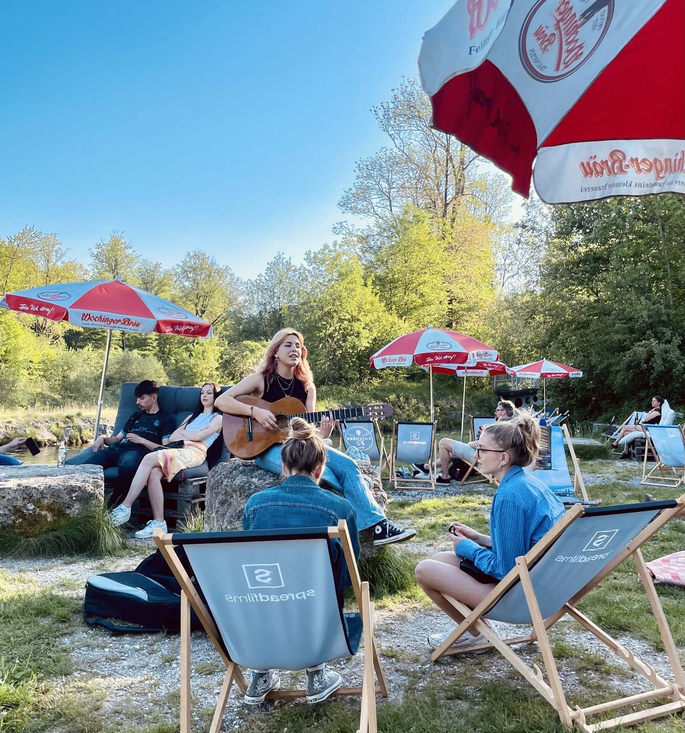 Gitarrenmusik zwischen Liegestühlen und rot-weißen Sonnenschirmen an der TRAUNBAR
