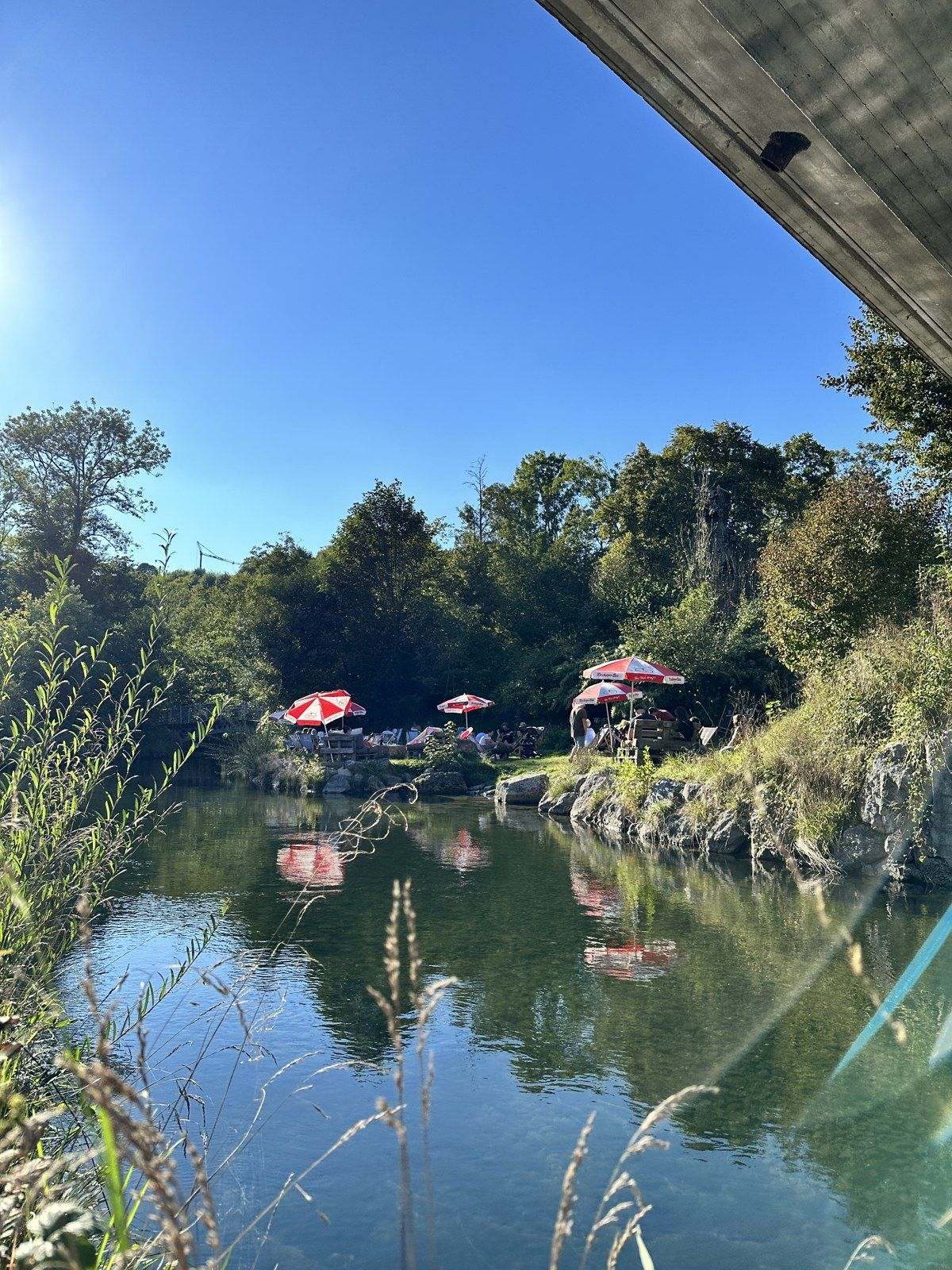 Die Sonnenschirme der TRAUNBAR spiegeln sich in der Traun
