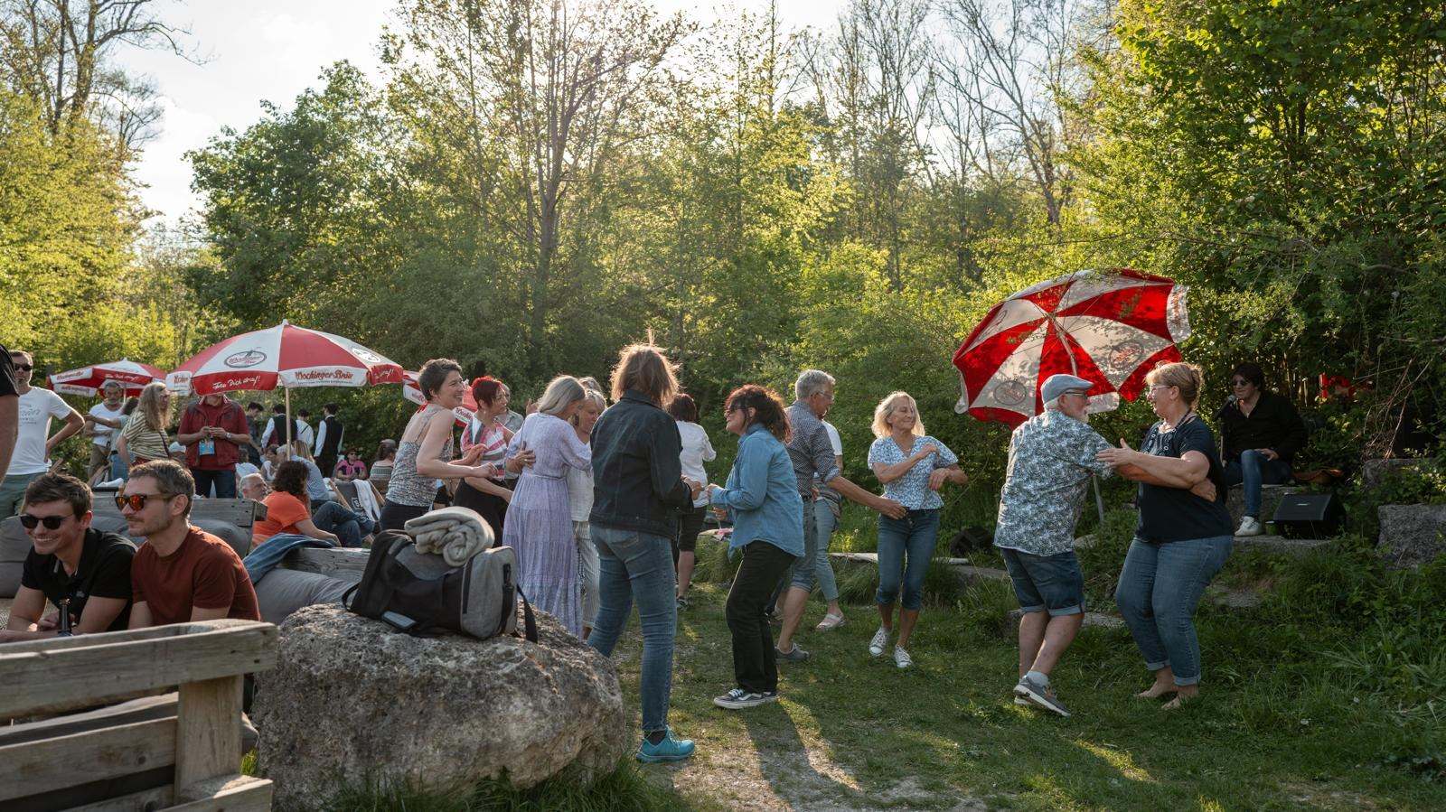 Gäste tanzen in der Abendsonne auf der Wiese an der TRAUNBAR